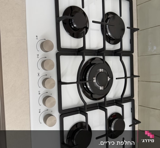 כיריים גז עם חמישה מבערים על משטח מטבח